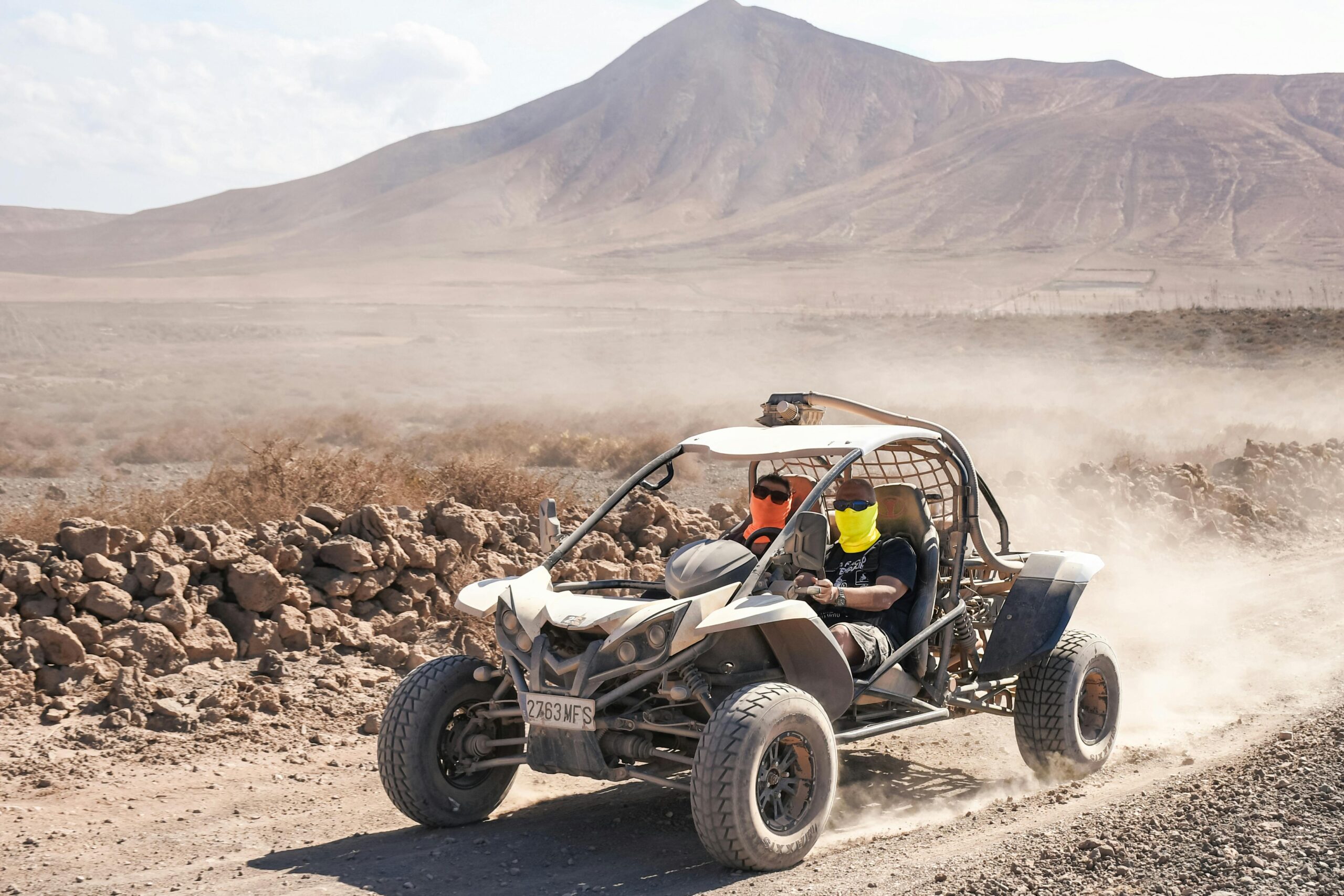 Home Experience the thrill of dune buggy racing across a rugged desert landscape with mountainous backdrop.